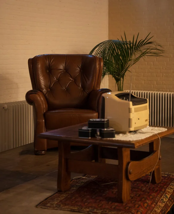 Het decor: fauteuil, salontafel en een oude radio